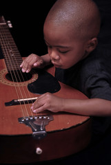 little boy plays the guitar