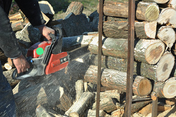 man with chainsaw cut the logs