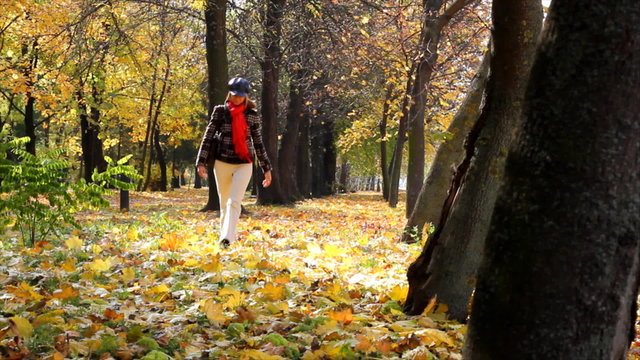 Woman in Park, walking and enjoying the autumn leaves