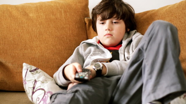 Young bored boy watching tv