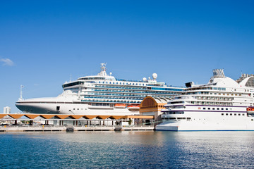 Fototapeta na wymiar Two White Cruise Ships on Calm Blue Water