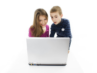 Teenager sister and little brother portrait sitting at notebook