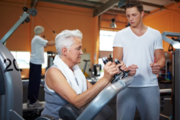 Seniorin bekommt Anleitung von Trainer