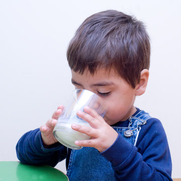 bambino che beve un bicchiere di latte