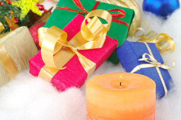 Lit orange candle and colorful presents