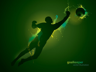 The football goalkeeper catches a ball on the dark background