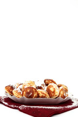 Poffertjes auf einer Serviette auf Weiß isoliert