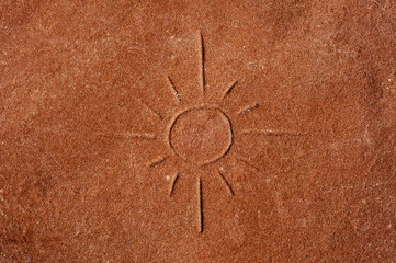 a sun carved on a red stone