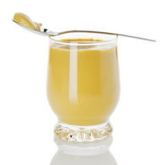glass of mustard with spoon