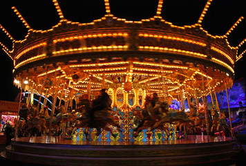 Obraz premium A Brightly Lit Fun Fair Carousel Ride at Night.