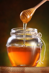 Sweet honey pouring from drizzler into the pot.