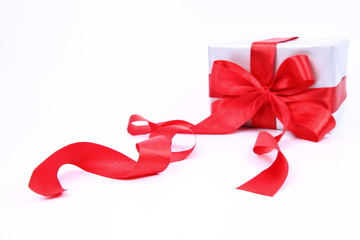 Gift,silver with a red bow (focus on the ribbon in front)