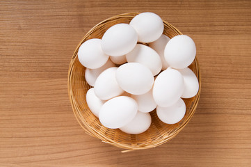 Many white eggs on the wooden table