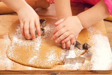 little girls cutting christmas  gingerbread cookies, hands only