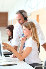 Business people working in front of computer with headphones