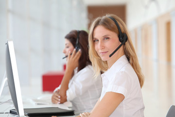 Business people working in front of computer with headphones
