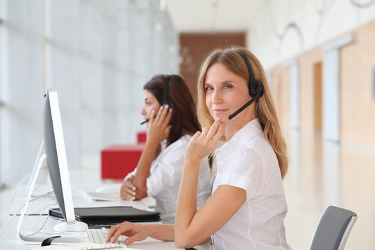 Business people working in front of computer with headphones