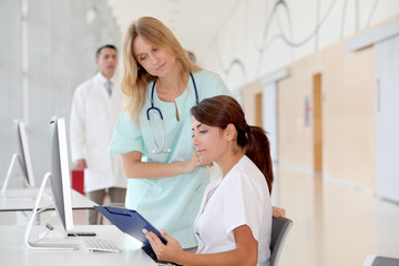 Obraz premium Nurse with intern working in front of computer