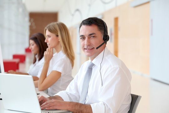 Business people working in front of computer with headphones