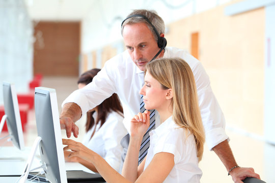 Business people working in front of computer with headphones - Powered by Adobe