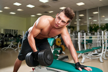 Fototapeta na wymiar Muscular man working his biceps