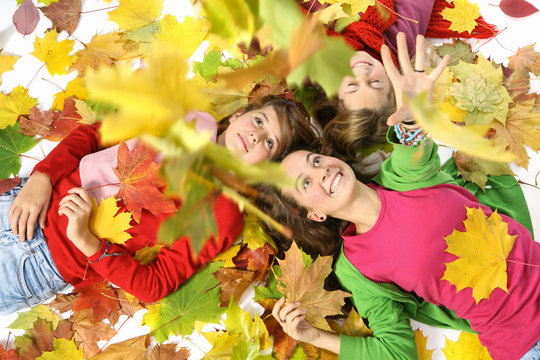 enfants jouant avec des feuilles jaune