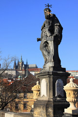 Fototapeta na wymiar Baroque Statue on the Prague Charles Bridge with Castle