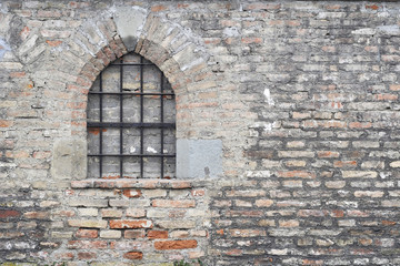 Mauer aus Steinen mit Fenster und Gitter