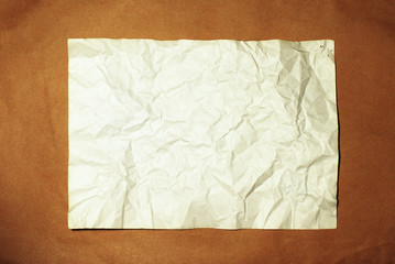 old crumpled paper on brown background