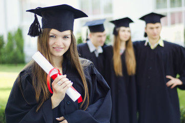 A graduate holding a diploma and smiling