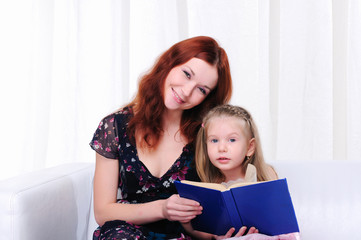 little girl and her mother read a book