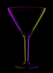 transparent colored empty martini glass on black