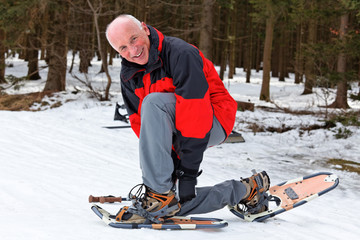 Senior beim Schnee Schuh Wandern im Winter