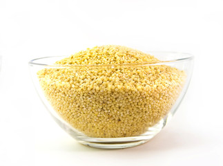 millet grains in bowl isolated