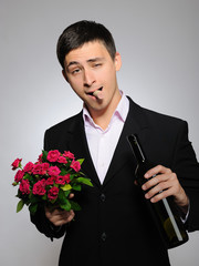 Handsome romantic young man holding rose flower and vine bottle - 27514830