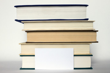 Stack of books and white card
