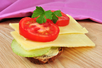 belegte Brotscheibe mit Gurke und Schnittkäse