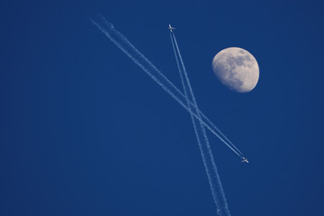 bright moon with aircraft on blue sky