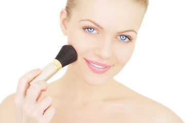 Young woman applying blusher isolated on a white background