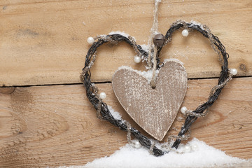 Wooden heart with perls in snow