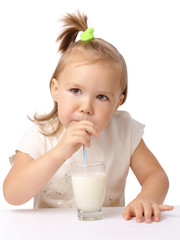 Little girl drinks milk using drinking straw