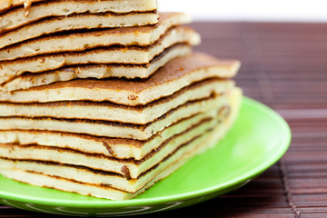 Pancakes on a plate on a bamboo mat