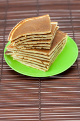 Pancakes on a plate on a bamboo mat