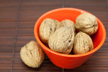 walnuts in a bowl on a bamboo mat