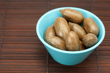 pecans in a bowl on a bamboo mat