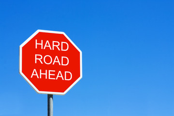 Hard Road Ahead road sign against a clear blue sky