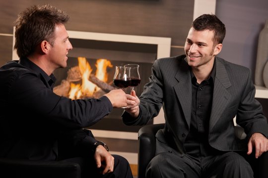 Businessmen clinking wine glasses