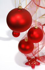 Hanging red glass balls with the ribbon on the white background