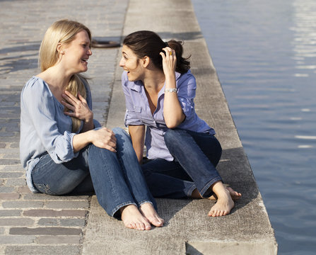 deux amies filles discutant au bord eau