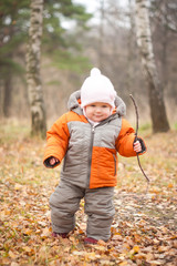 young cheerful baby walking in autumn forest